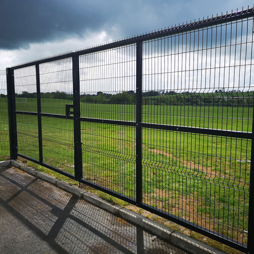 A large green heavy duty double gate attached to a fence at the Billy Neil Playing Field